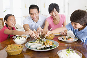 Mother, father, and 2 children sitting around the table eating